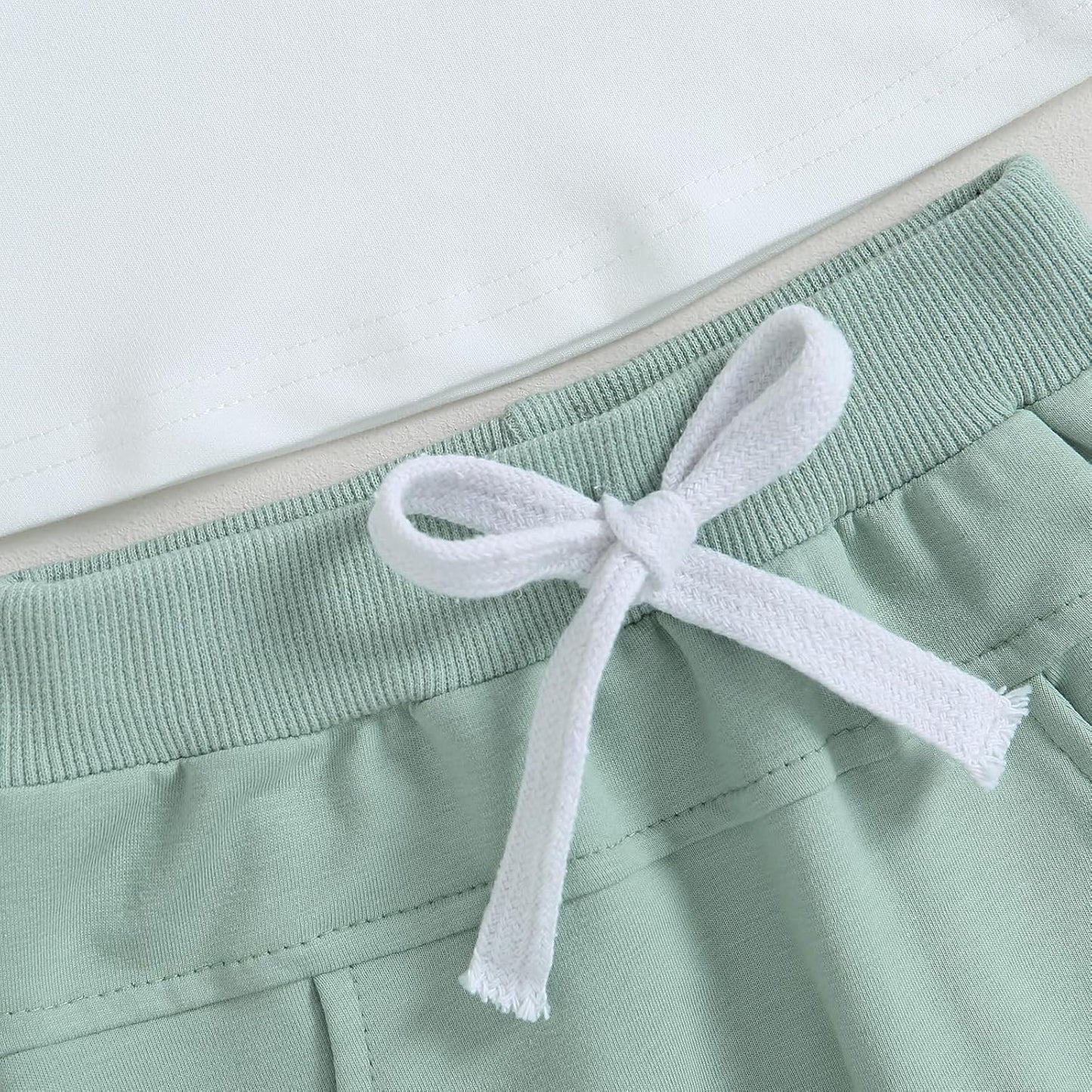 Grüne Jogginghose mit weißem Kordelzug, Baumwolle, bequem, sportlich, Freizeitkleidung.