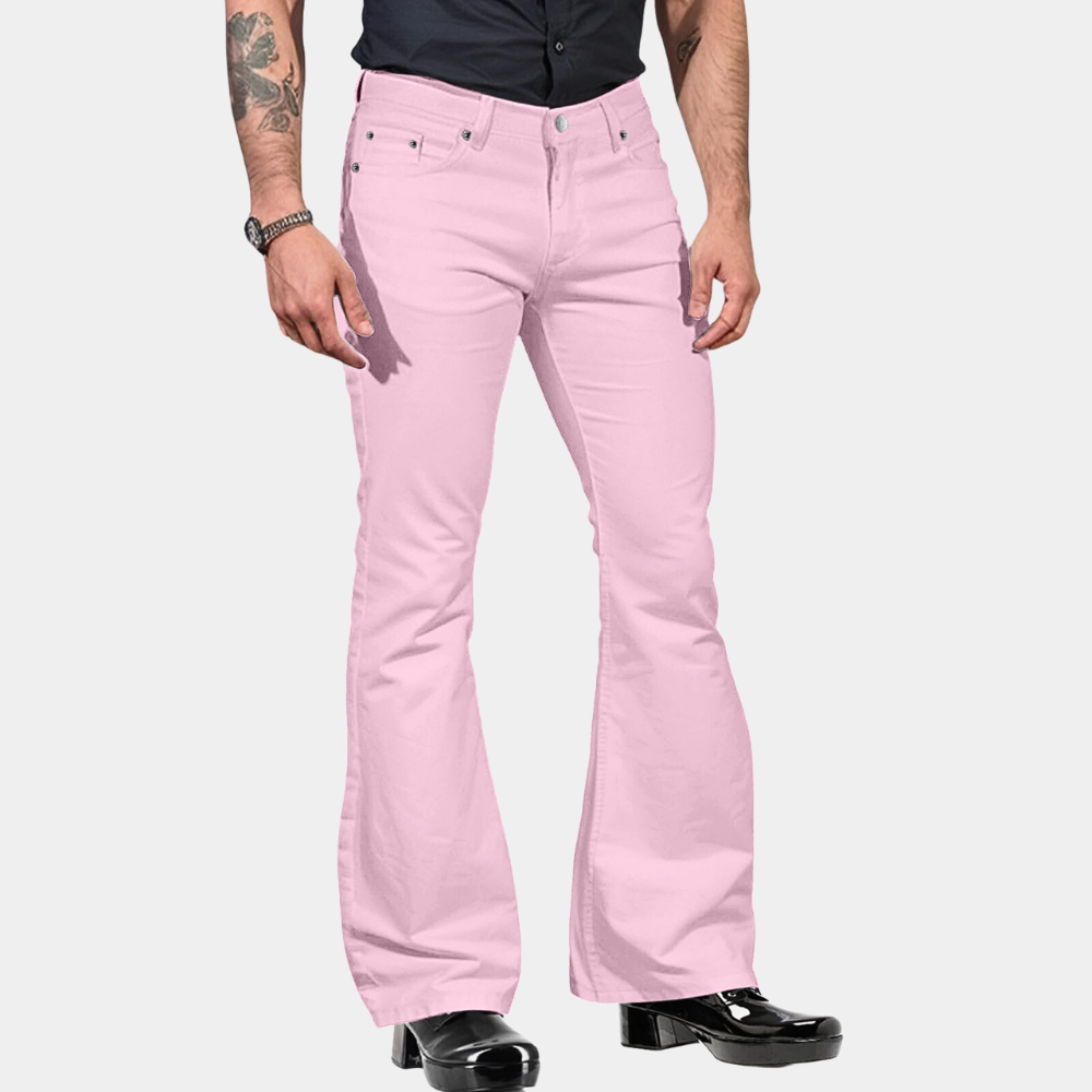 Mann in rosa Schlaghose, schwarze Stiefel, schwarzes Hemd, modische Herrenbekleidung.