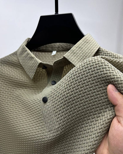 Beiges Herrenhemd mit strukturiertem Muster, Knopfleiste, elegantes Design, auf Kleiderbügel.