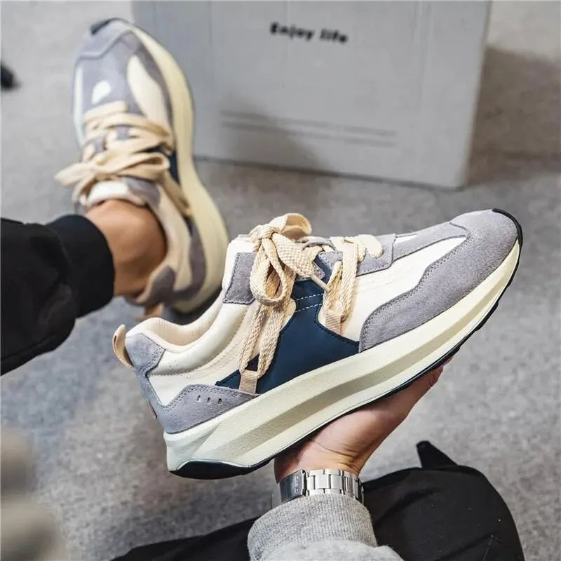 Grauer und weißer Herrensneaker, lässiger Stil, elastische Schnürsenkel, bequemes Design.