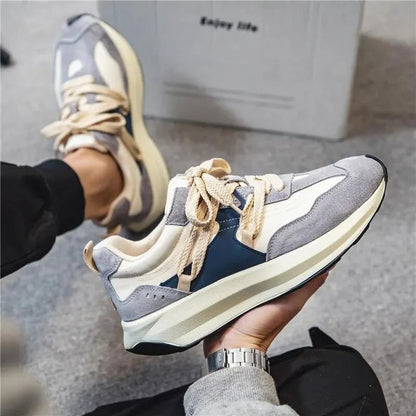 Grauer und weißer Herrensneaker, lässiger Stil, elastische Schnürsenkel, bequemes Design.