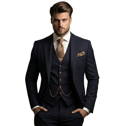 Man bär kostymen i mörkt marinblått med beige slips, bosscheck i bröstfickan och klockkedja på västen, händerna i fickorna. 1