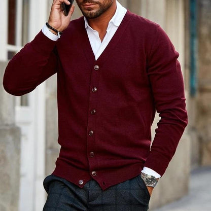 Mann in bordeauxroter Strickjacke, V-Ausschnitt, Knopfleiste, modisch, elegant, Herbstmode.