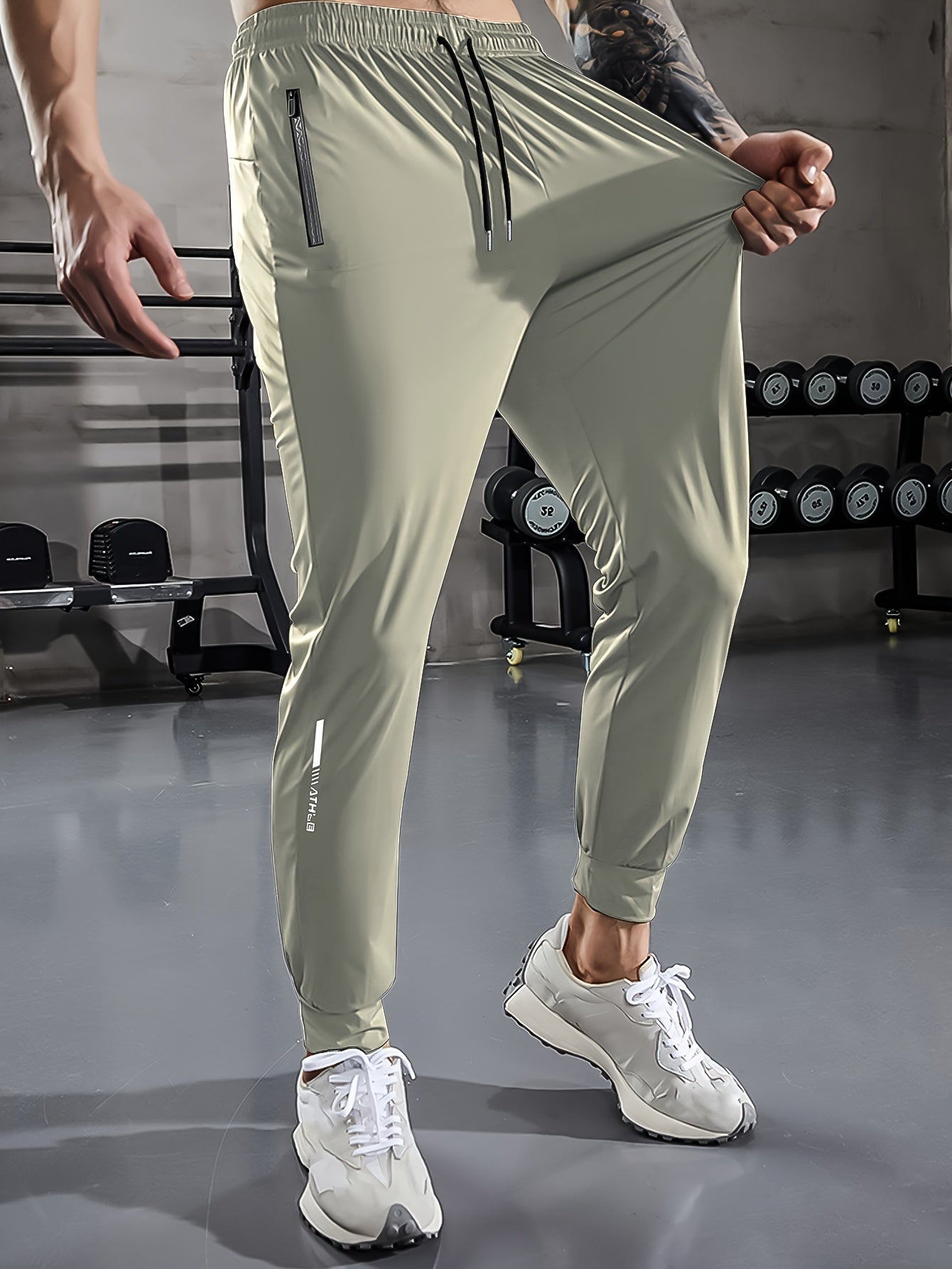Herren Sporthose, hellgrau, mit Reißverschlusstaschen, elastisch, ideal für Fitnessstudio.
