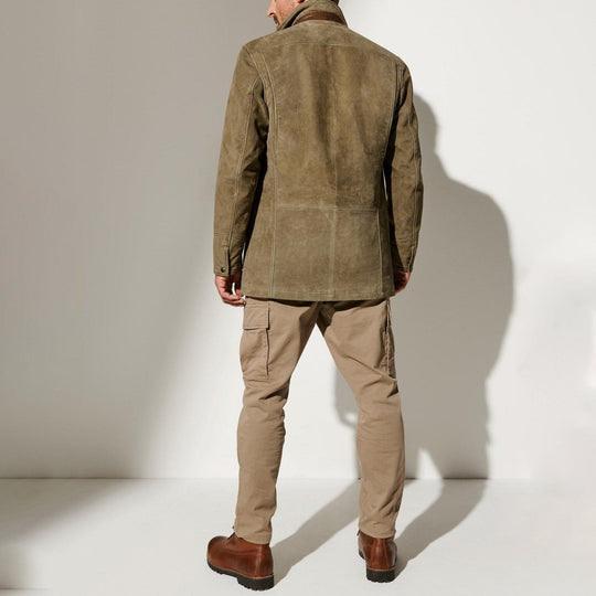 Mann in olivgrüner Wildlederjacke und beigen Hosen, Rückansicht, modische Herrenbekleidung.