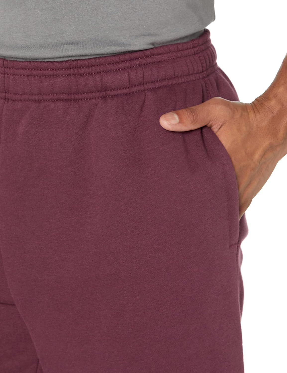 Mann in bordeauxroter Jogginghose mit elastischem Bund und Seitentasche, Freizeitmode.