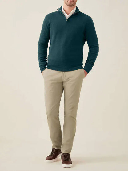 Mann trägt grünen Kaschmir-Pullover mit Reißverschluss, beige Hose, braune Schuhe.