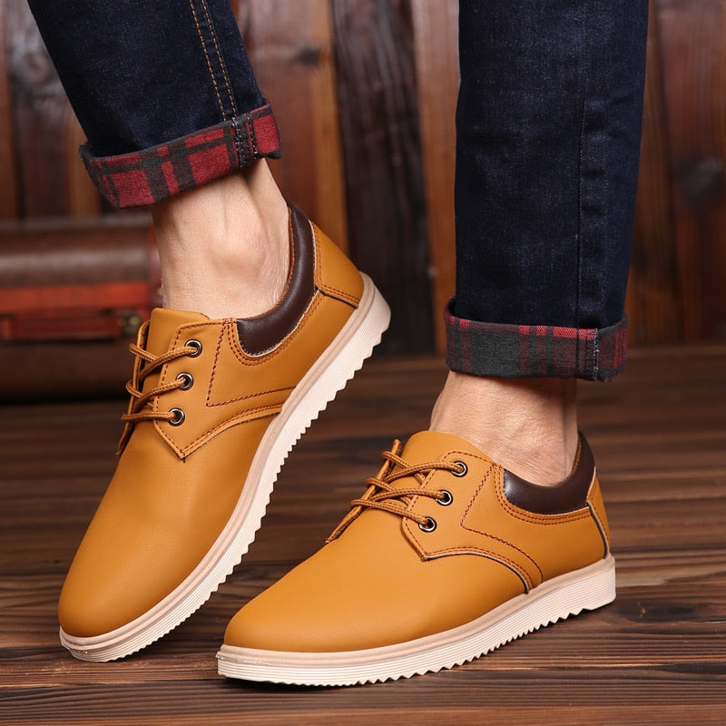 Braune Herrenschuhe aus Leder, lässig, mit Schnürsenkeln, auf Holzboden, modisch.