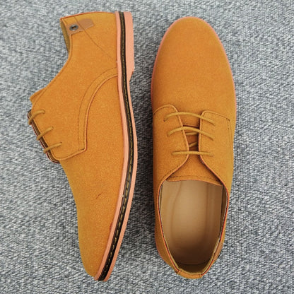 Braune Wildleder-Herrenschuhe mit Schnürung auf grauem Teppich. Elegante Freizeitschuhe.
