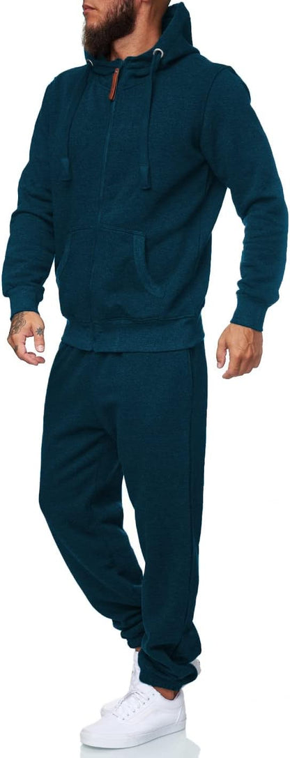 Mann in dunkelblauem Jogginganzug mit Kapuze und weißen Sneakers, Freizeitmode, Sportbekleidung.