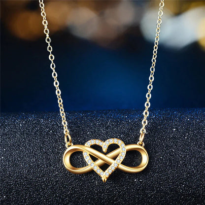 Goldene Halskette mit Herz- und Unendlichkeitsanhänger, verziert mit Kristallen, eleganter Schmuck.