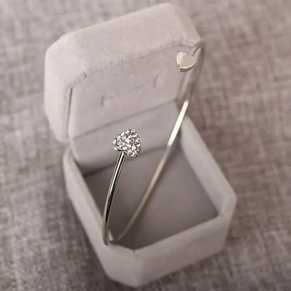 Silbernes Herzarmband mit Diamanten in grauer Schmuckschatulle, elegantes Schmuckdesign.