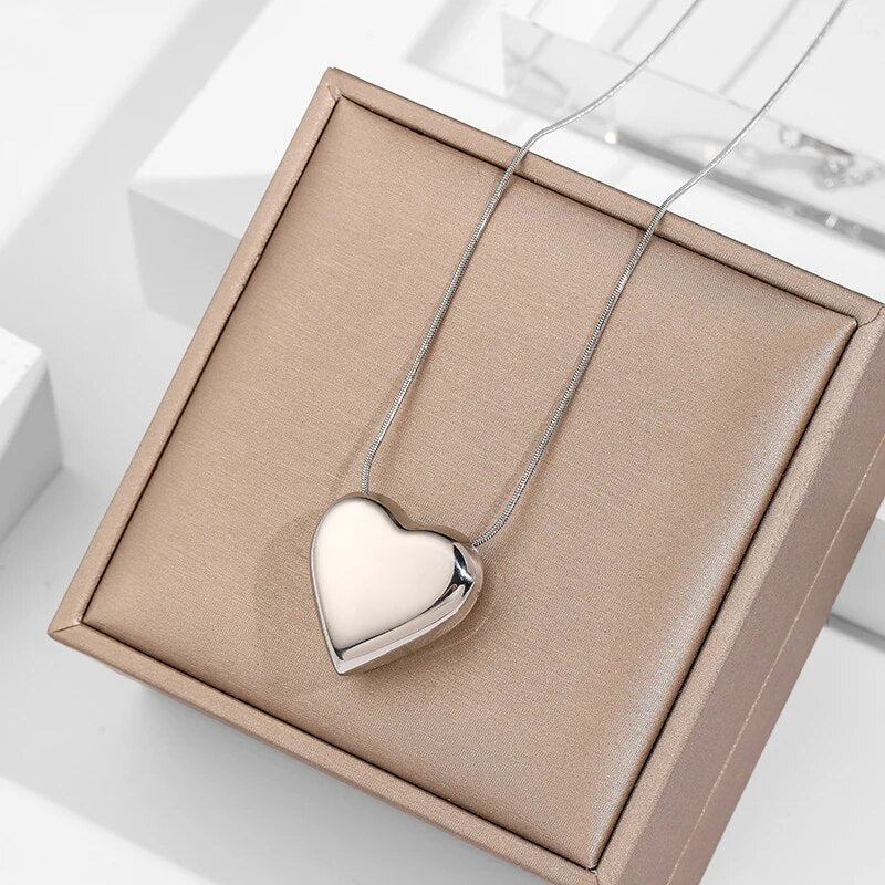 Herzförmiger Silberanhänger auf Kette, Schmuck, Geschenk, elegantes Design, auf beigem Etui.