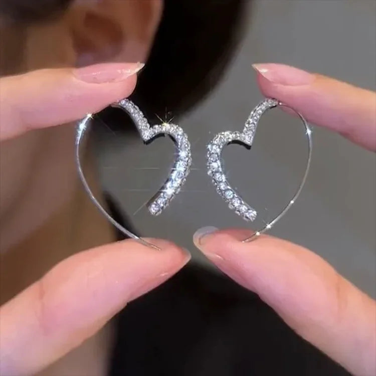 Herzförmige Ohrringe, Silber, mit Strasssteinen, eleganter Schmuck, modisches Accessoire.