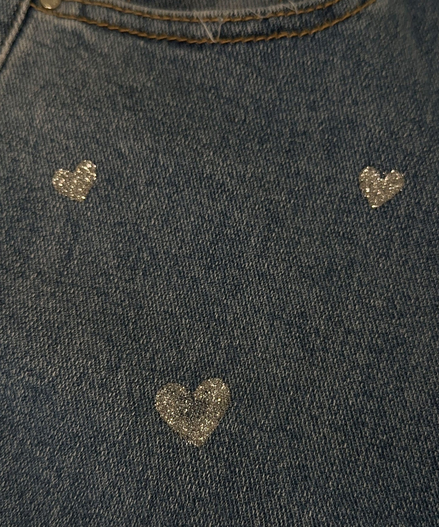 Dunkelblauer Jeansstoff mit glitzernden Herzmotiven, modisch, stilvoll, Textildesign.