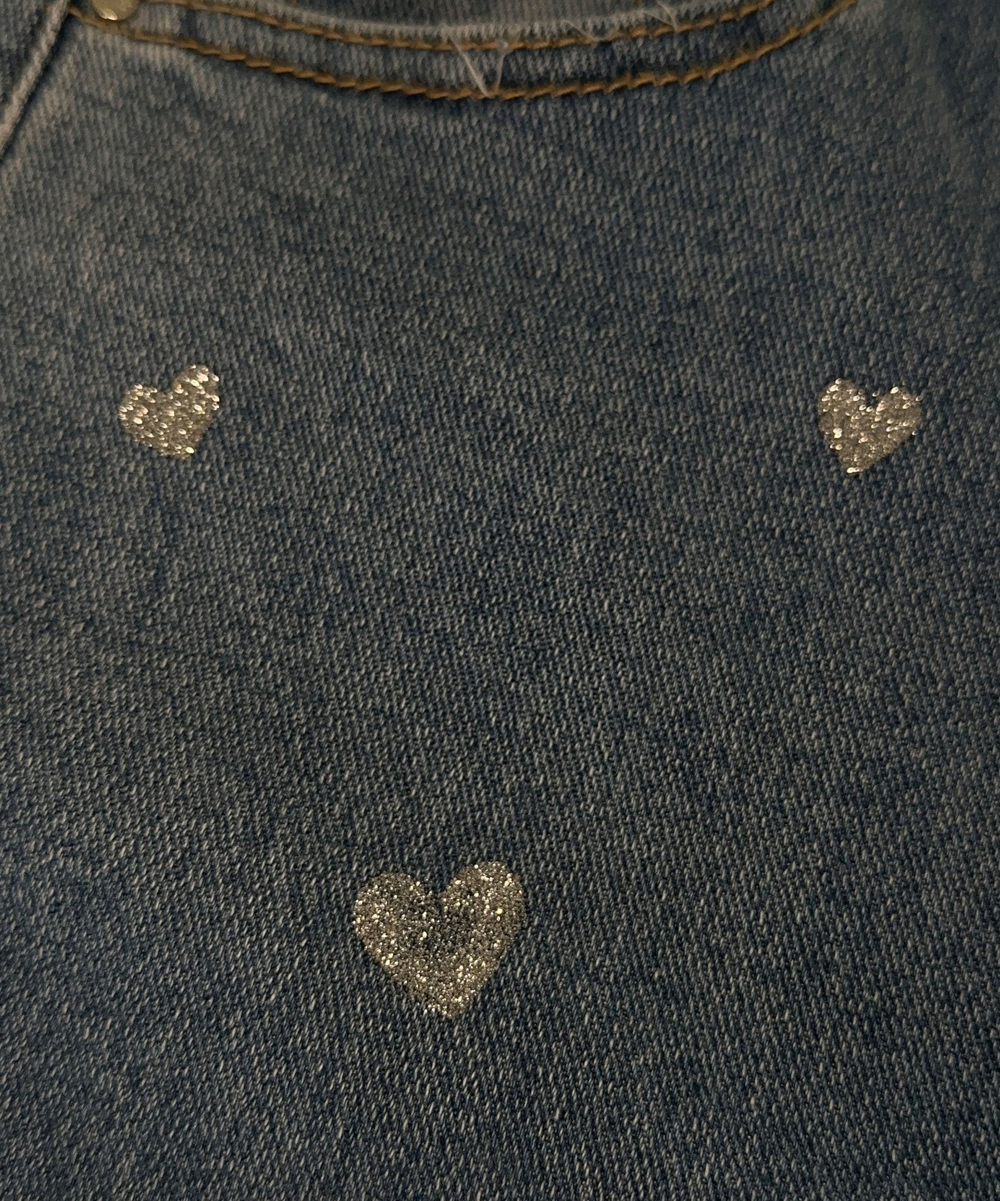 Dunkelblauer Jeansstoff mit glitzernden Herzmotiven, modisch, stilvoll, Textildesign.