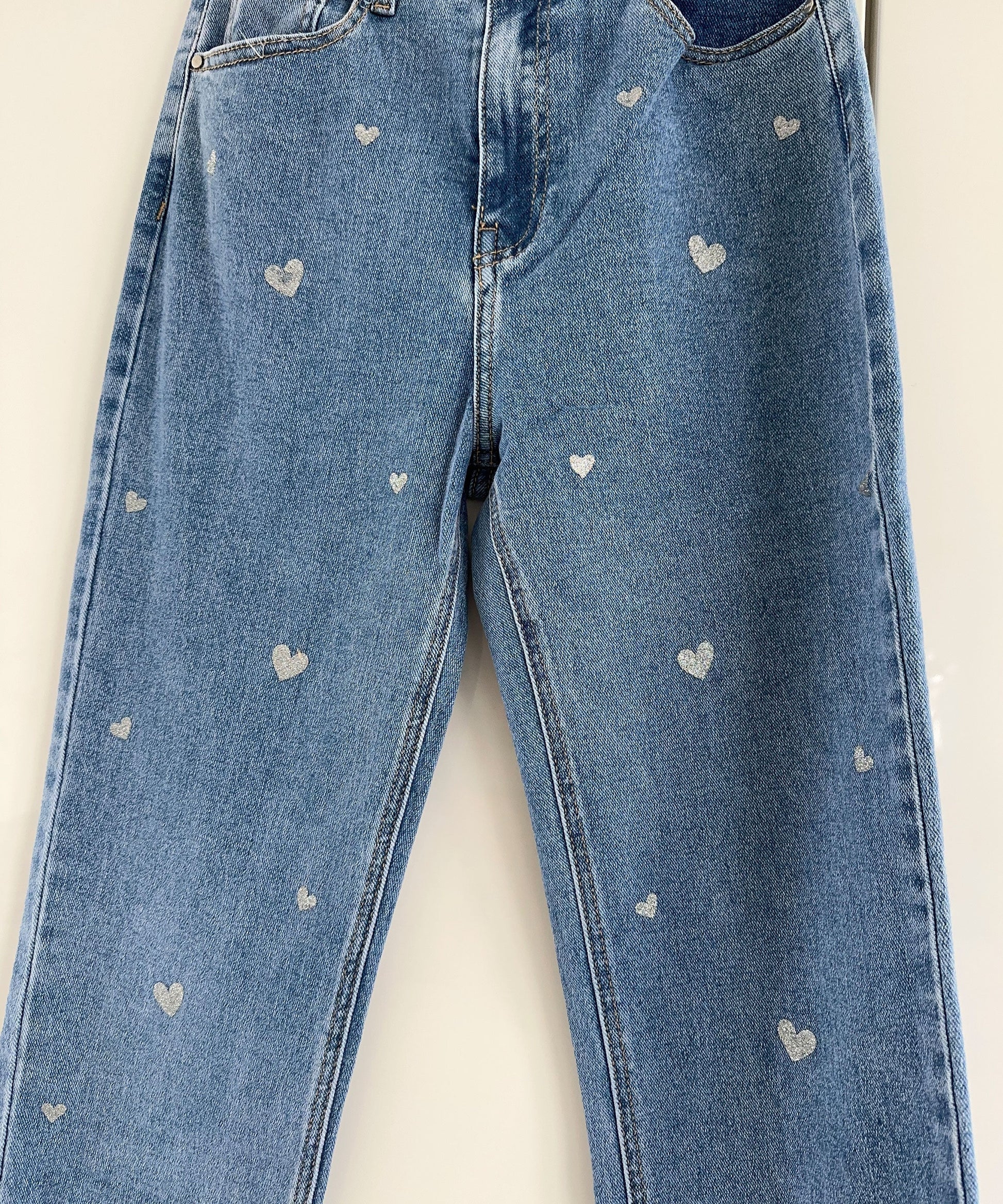 Blaue Jeans mit weißen Herzmustern, Damenmode, lässiger Stil, Denim-Hose.