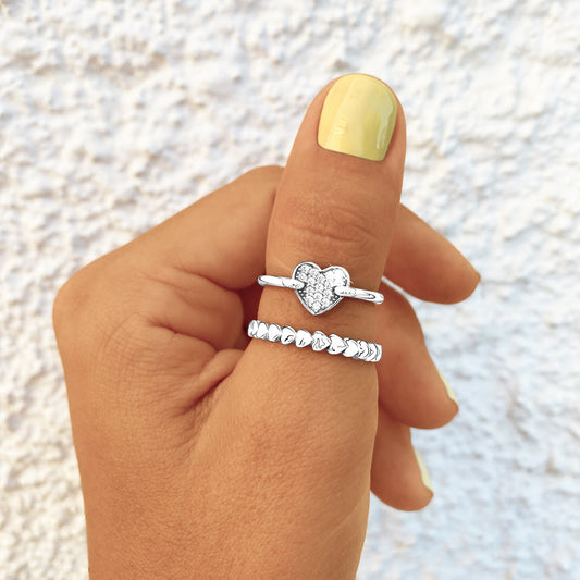 Silberringe mit Herzdesign, Damenmode, Schmuck, eleganter Stil, Nahaufnahme, Hand, Nagellack.