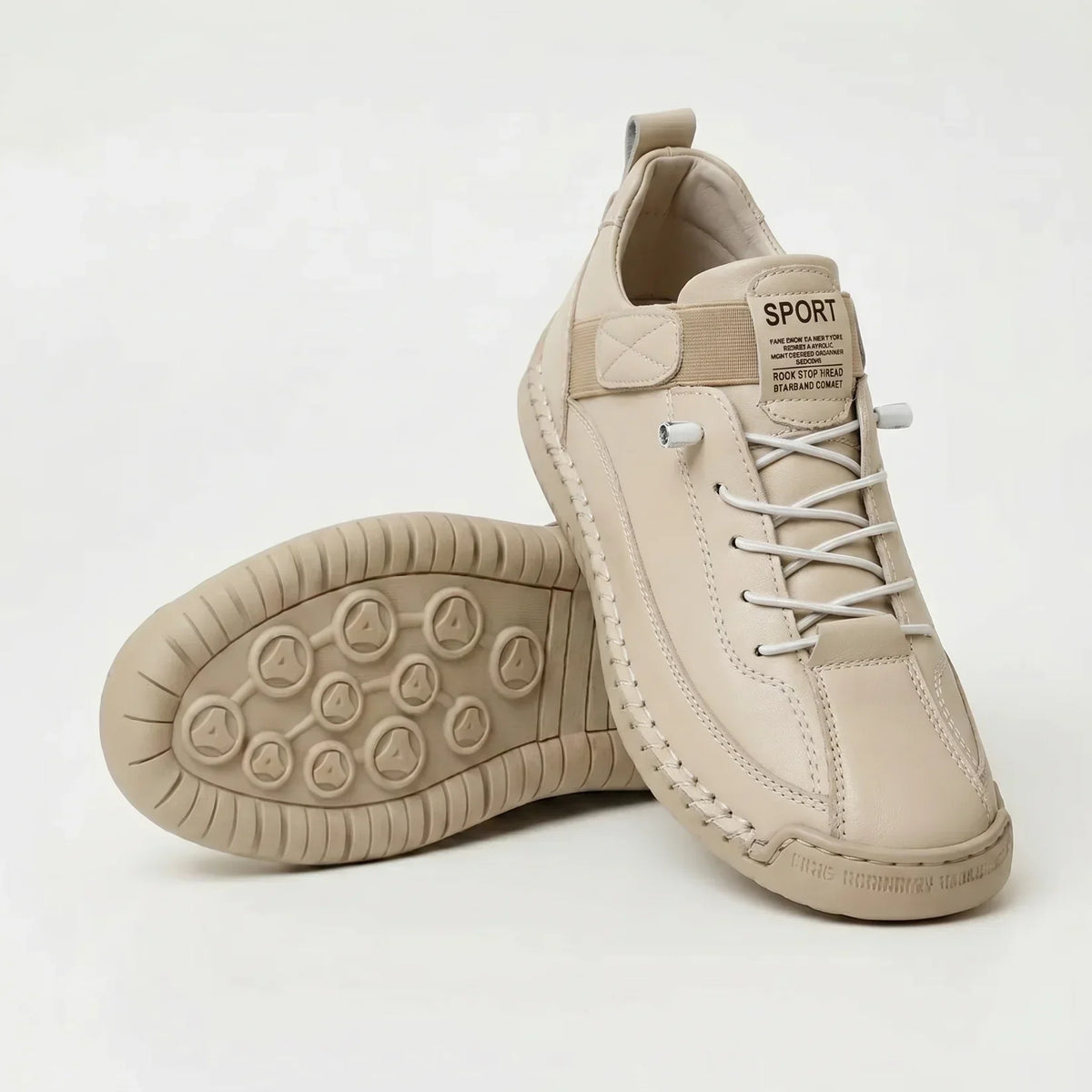 Krämbeige skor i slätt material med vita elastiska snören och beige sula, ett par vänt upp och ner. 10
