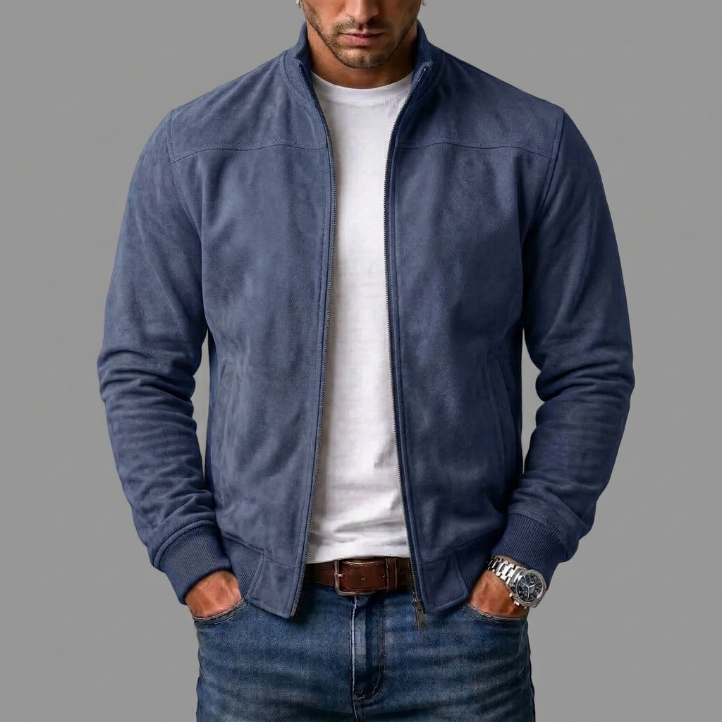 Man bär jackan i mörkt blågrått, öppen över en vit t-shirt och jeans, med händerna i fickorna. 6