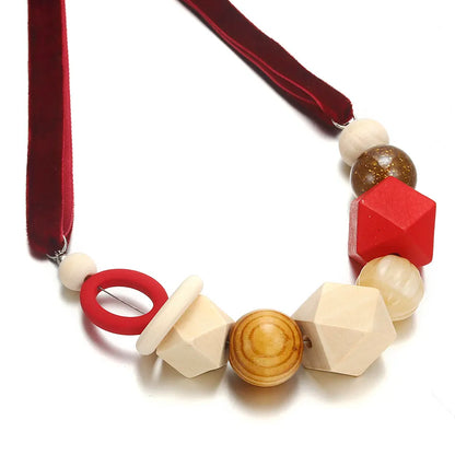 Bunte Holzperlenkette mit roten und naturfarbenen geometrischen Formen, handgefertigt.
