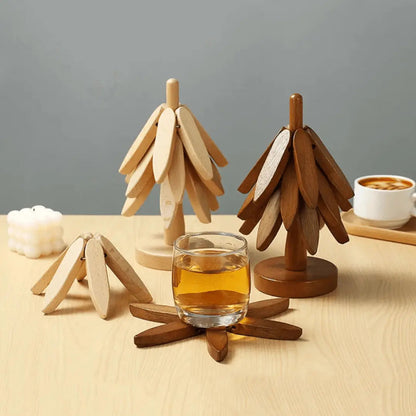 Holzuntersetzer in Baumform, naturfarben, auf Holztisch mit Glas und Kerze, modernes Design.