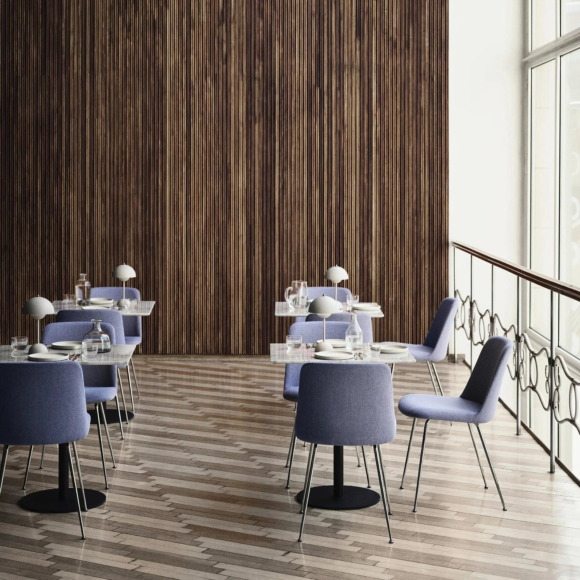 Moderne Esszimmerstühle in Blau, Holzwand, Fischgrätboden, stilvolles Interieur.