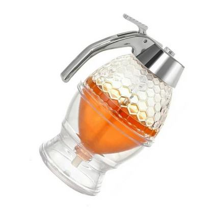Honigspender aus Glas mit Metallgriff, wabenförmiges Design, ideal für Frühstückstisch.