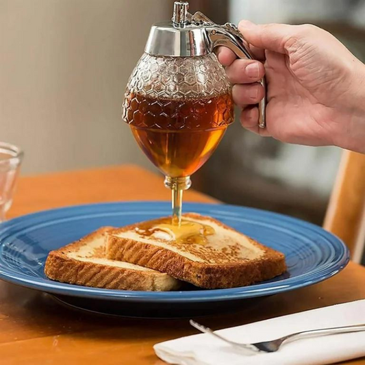 Hand gießt Honig aus Glasbehälter auf Toast auf blauem Teller, Frühstück, Küche, Honigspender.