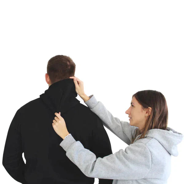 Zwei Personen in Kapuzenpullovern, eine in Schwarz, die andere in Grau, vor weißem Hintergrund.