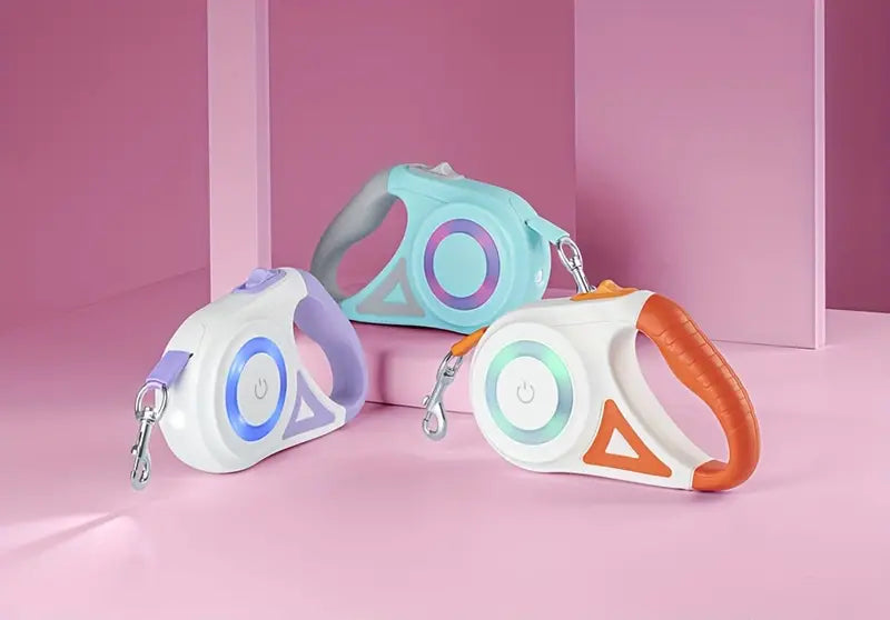 Drei bunte, einziehbare Hundeleinen auf rosa Hintergrund, ergonomisches Design.