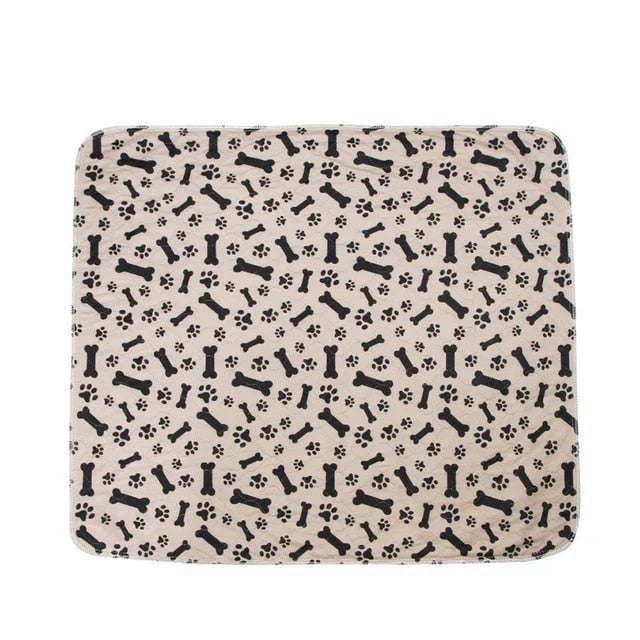 Beige Hundedecke mit schwarzen Knochen- und Pfotenabdrücken, weiches Material, ideal für Haustiere.