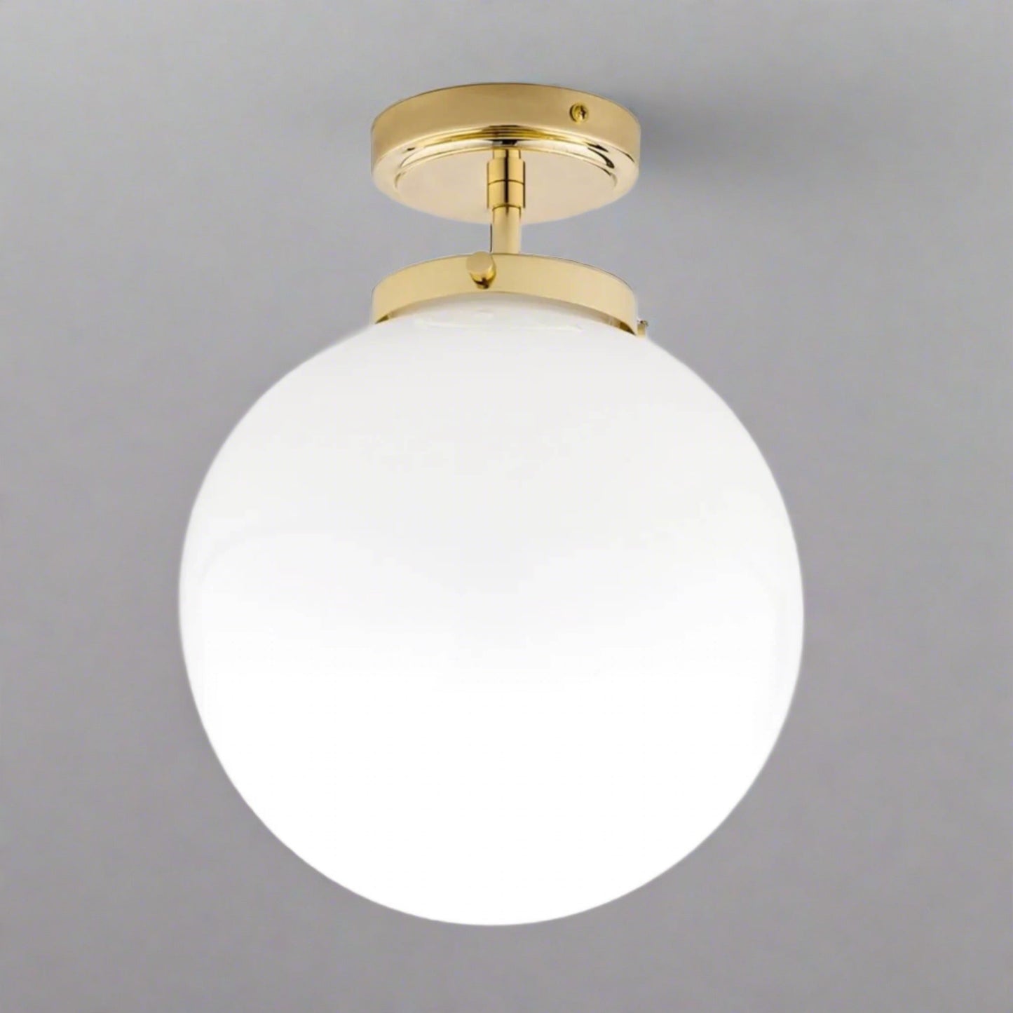 Goldene Deckenleuchte mit weißem Glaskugel-Schirm, modernes Design, ideal für Badezimmer.