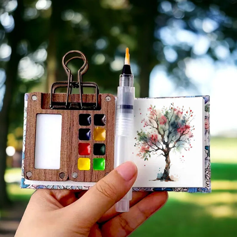 Mini-Aquarell-Set mit Pinselstift, Holzpalette, Farben, Skizzenbuch, ideal für unterwegs.
