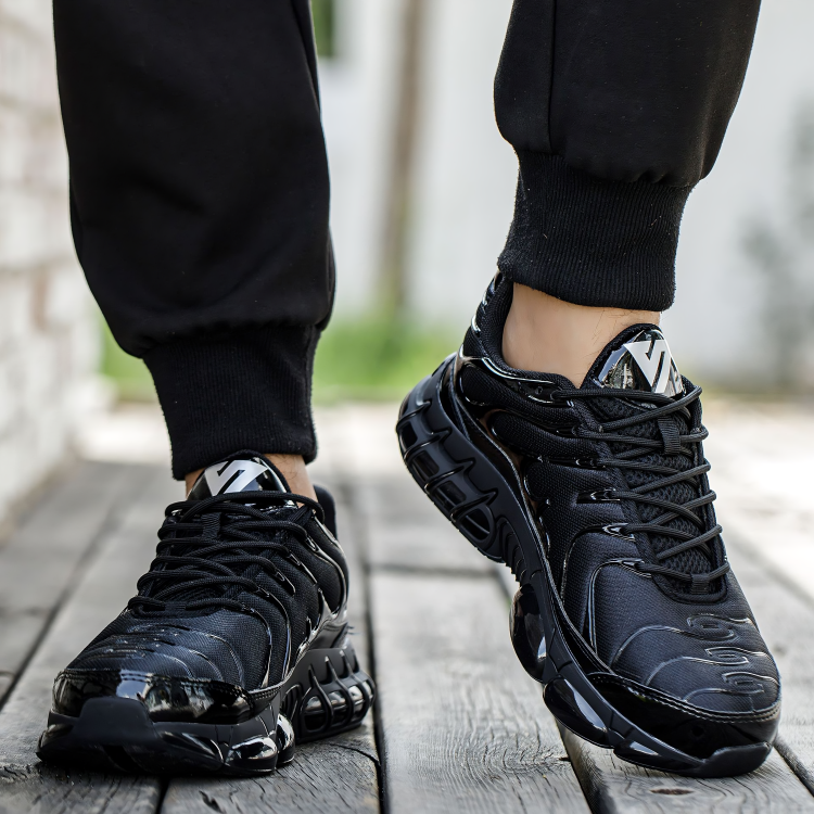 Schwarze Herren-Sneaker, atmungsaktiv, sportlich, rutschfest, auf Holzweg getragen.
