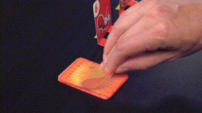 Hand legt Karte auf Tisch, rotes Kartenspiel, Brettspiel, Strategie, Unterhaltung, Familienaktivität.