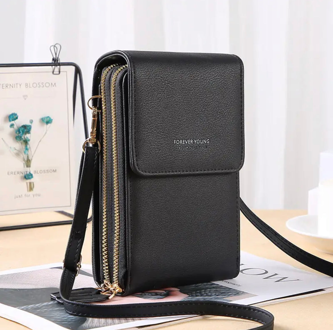 Schwarze Lederhandtasche mit Reißverschlüssen und Schulterriemen, elegant und modern.