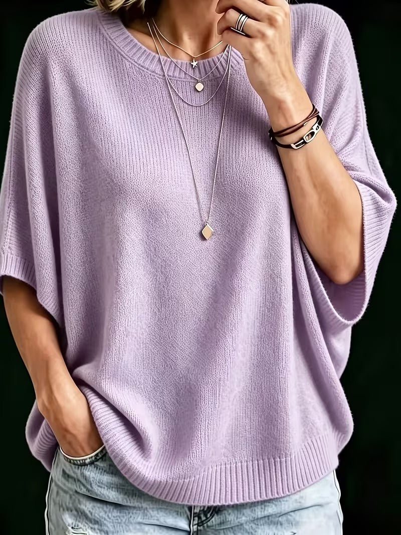 Närbild på lila stickad topp med batwing-ärmar, burna med lagda halsband och läderarmband. 7
