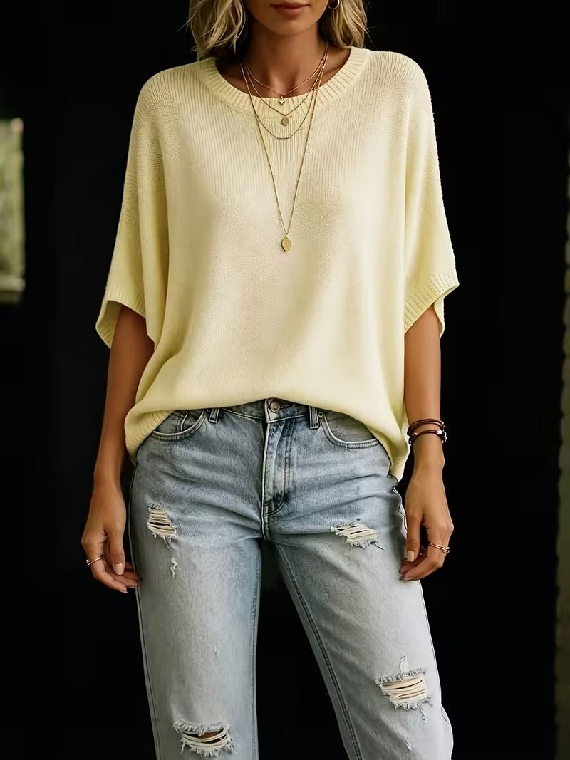 Blekgul stickad topp i helfigur framifrån, stylad med ljusa slitna jeans och långa halsband. 5