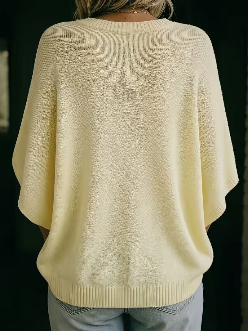 Blekgul stickad topp sedd bakifrån, med ribbad hals, ribbade ärmslut och ribbad nederkant. 6