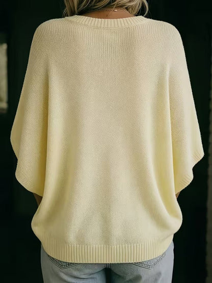 Blekgul stickad topp sedd bakifrån, med ribbad hals, ribbade ärmslut och ribbad nederkant. 6