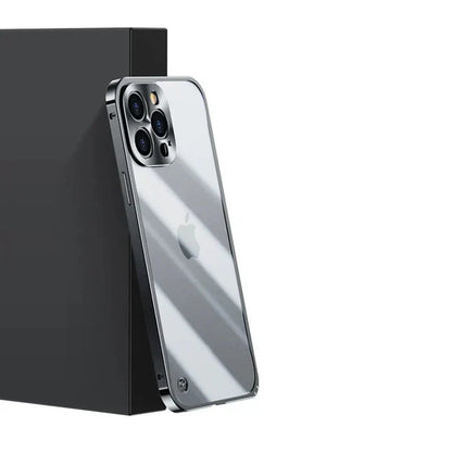 Silbernes Smartphone mit Dreifachkamera und Apple-Logo, schräg an schwarzer Box gelehnt.