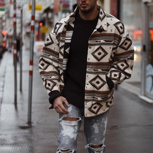 Mann in gemusterter Jacke und zerrissener Jeans auf Stadtstraße, modischer Streetwear-Look.
