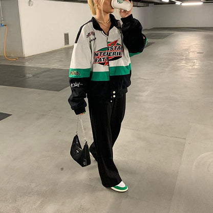Frau in bunter Windjacke, schwarze Hose, weiße Sneaker, Tiefgarage, Mode, Streetwear.