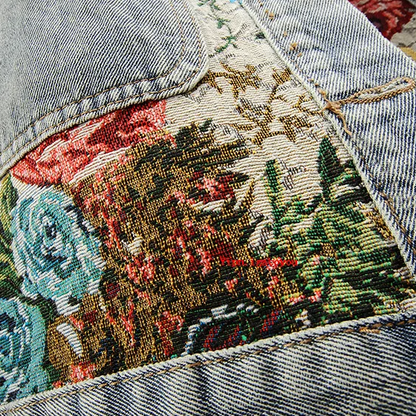 Nahaufnahme bestickte Jeansjacke mit floralen Mustern, Vintage-Stil, bunte Blumenstickerei.