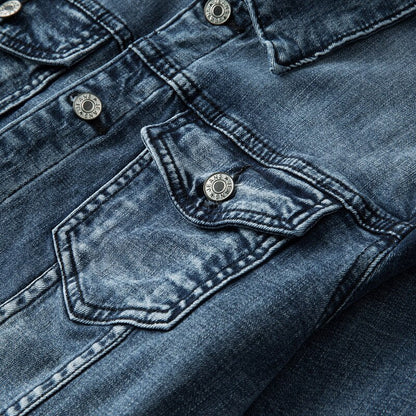 Nahaufnahme einer blauen Jeansjacke mit Taschen und silbernen Knöpfen, Denim-Textur.