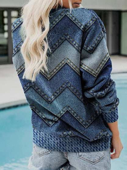 Frau in blauem Jeans-Pullover mit Zickzackmuster am Pool, modische Freizeitkleidung.