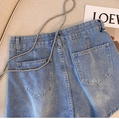Hellblaue Jeansrock mit Taschen und Kettengürtel auf beigem Sofa, modisch, Damenbekleidung.