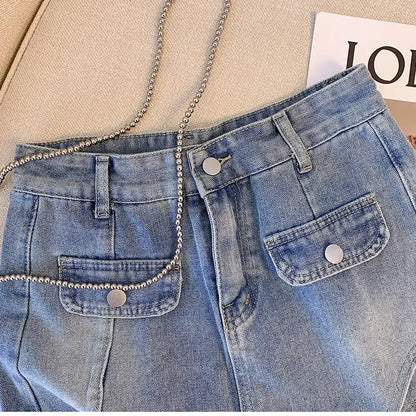 Blaue Jeans mit Taschen und Kettenriemen auf beigem Hintergrund, modisch, lässig.