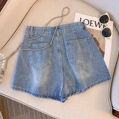 Damen Jeansshorts blau, lässig, Sommermode, auf Sofa mit Sonnenbrille und Magazin.